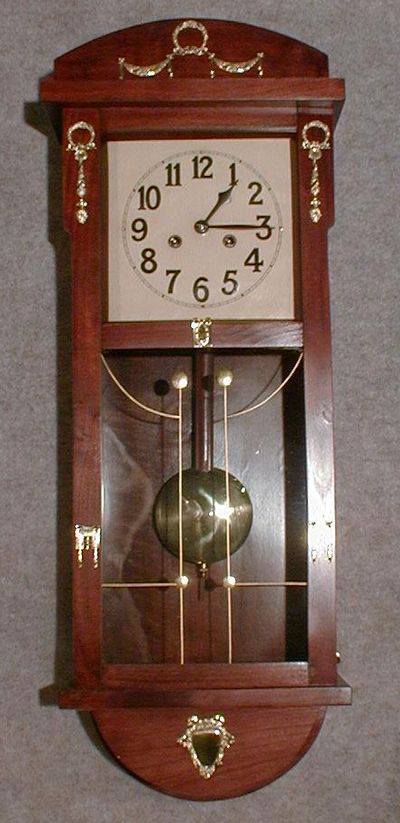 JUNGHANS BOX CLOCK. MAHOGANY FINISH WITH APPLIED BRASS DECORATIONS. CIRCA 1920. — Antique Clocks Price Guide
