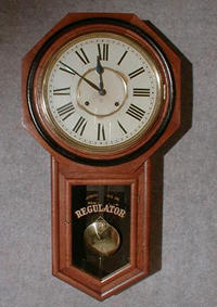 ANSONIA "REGULATOR A" WALL CLOCK. THE CASE IS ASH AND HAS A BLACK BANDED BEZEL. CIRCA 1905-1910. — Antique Clocks Price Guide