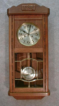 GERMAN BOX CLOCK IN AN OAK VENEERED CASE WITH BEADING DOWN THE DOOR SIDES AND AN APPLIED CARVING AT THE TOP. CIRCA 1910-1920. — Antique Clocks Price Guide
