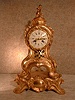 FRENCH CAST BRASS IN A GILT FINISH SERPENTINE STYLE MANTEL CLOCK ON AN ATTACHED BASE. CIRCA 1860-1880.