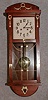 JUNGHANS BOX CLOCK. MAHOGANY FINISH WITH APPLIED BRASS DECORATIONS. CIRCA 1920.