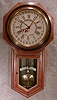 ANSONIA "REGULATOR A" WALNUT VENEER WITH A BLACK BAND BEZEL.. CIRCA 1900-1910.