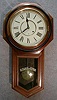 ANSONIA "REGULATOR A" IN A WALNUT CASE WITH BLACK BANDED BEZEL. NEW PAPER ROMAN DIAL.. CIRCA 1905-1910.