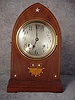 German Lancet Top Mantel Clock In A Mahogany Veneered Case With Satin Wood Banding, Marquetry And Mother Of Pearl Inlay. Circa 1900-1910.