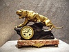 French Art Deco Style Mantel Clock With A Rose Colored Marble Base That Has An Ormolu Decoration On The Front Of The Base, A Black Spelter Rock (Signed T. Cartier) With A Gilt Jaguar On Top. Circa 1920-1930.