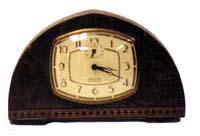 E. Ingraham Co. 8 day alarm clock in a wood case, 9 1/2 inches wide by 6 inches high. — Antique Clocks Price Guide