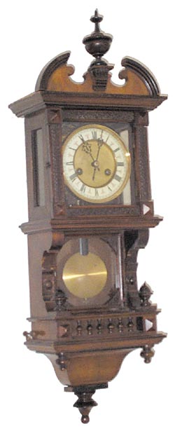 Hamburg American wall regulator in a free swinger type case, where the pendulum is hanging behind a glass door. — Antique Clocks Price Guide