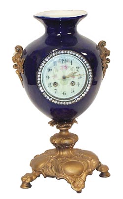French Urn Clock. Cobalt blue urn is 15 inches high with a gold painted metal base with lions paw feet, and side ornaments that depict mythical lions heads. — Antique Clocks Price Guide