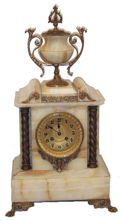 French mantle clock, white onyx with bronze adornments, feet, urnholder, column bases and caps, ornaments above and below the dial. — Antique Clocks Price Guide