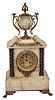 French mantle clock, white onyx with bronze adornments, feet, urnholder, column bases and caps, ornaments above and below the dial.