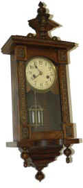 Miniature German wall clock, 24 inches high, espousing a lot of attractive wood work. — Antique Clocks Price Guide