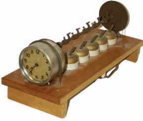 An automatic alarm system called, "Never Fail Time Switch", made by "J.E. Gilson Co. Port Washington, Wis". Patented 1923. — Antique Clocks Price Guide