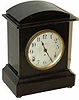 Seth Thomas mantle clock, "Dana" model in a wood case with a mahogany adamantine finish, stands 11 inches tall.