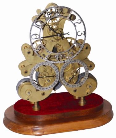 Three dial skeleton clock with a double fusee movement. The large time dial is at the top, dial at bottom left shows weeks of the year, and dial at the bottom right shows the day of the month. — Antique Clocks Price Guide