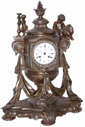 Large French metal clock, adorned with cupids and many other cast ornaments, with an early silk thread suspension movement, ca around 1850. The case is 21" tall and very heavy. — Antique Clocks Price Guide