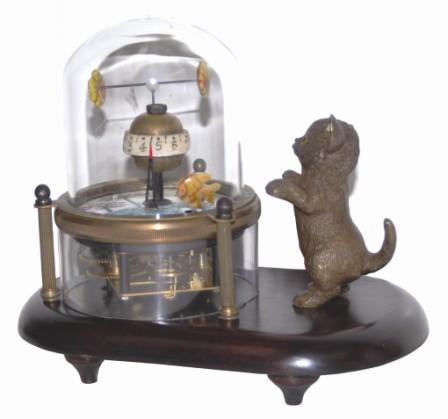 Novelty clock featuring a cat and animated fish. The brass case rests on a wood base. — Antique Clocks Price Guide