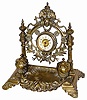 French brass clock/inkwell, ca 1885. The case is 10" wide, 10" high, cast brass with decorations at the top, and a wreath under the clock.