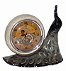 Animated novelty clock that features a ceramic peacock with an alarm clock on its back. The case is 8" wide and almost 8" high.