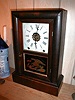 Eight-day mantle clock with strike on the hours and alarm mechanism.