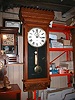 Eight-day weight-powered wall regulator with solid Oak case.