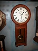 Round top, solid Oak weight-powered wall clock.