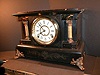 Enameled Black mantle clock with hourly strike.