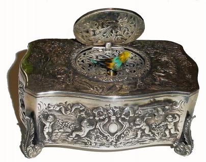 C.1950, Swiss, Singing Bird Box in a silver [.925] embossed case, and with brightly colored enamel scene on the bird cover. — Antique Clocks Price Guide