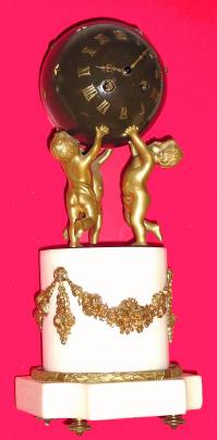 C.1890 French, 8-Day, 3-Cherubs, ormolu and marble mantel clock, the cherubs holding aloft a dark green globe containing the time and bell strike movement [lever]; the dial consisting of gilt applied numerals. — Antique Clocks Price Guide