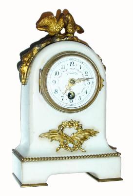 C.1890, French, Small White Marble and ormolu desk clock, with tiny round timepiece movement with platform spanning the plates at top. The fancy porcelain dial with polychrome decorations, and signed by Viennese retailer: Conrad Felsing, Hofuhrmacher. — Antique Clocks Price Guide