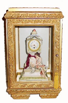 C.1900, French, Mini Figural Clock, a seated lady holding a shield with a Greek goddess embossed on the front surface, in a gilded modern case. — Antique Clocks Price Guide