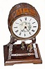 C.1890, German, ÒSWINGING CATÓ timepiece, 8-day. The movement contained within a painted tin barrel, painted to look like wood. The pendulum is a cat with red bandanna, swinging front to back, a string from the pendulum to a monkeyÕs arm which makes it look like the monkey is swinging the cat. 