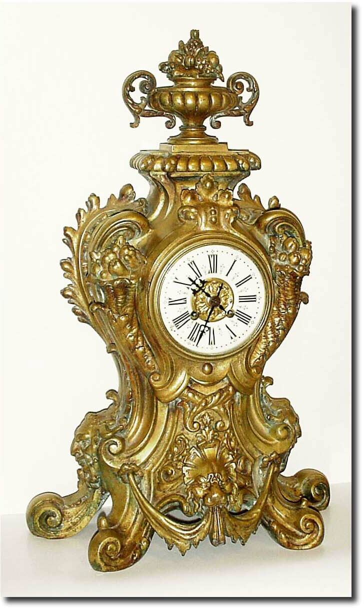C.1880, French, Large and Impressive Bronze clock, a lion at the base amidst large scrolls, the dial flanked by two cornucopia, overflowing with vegetables, and the case surmounted by an urn with pineapple and apples; note bronze has blue and brown oxidation in the crevices. — Antique Clocks Price Guide