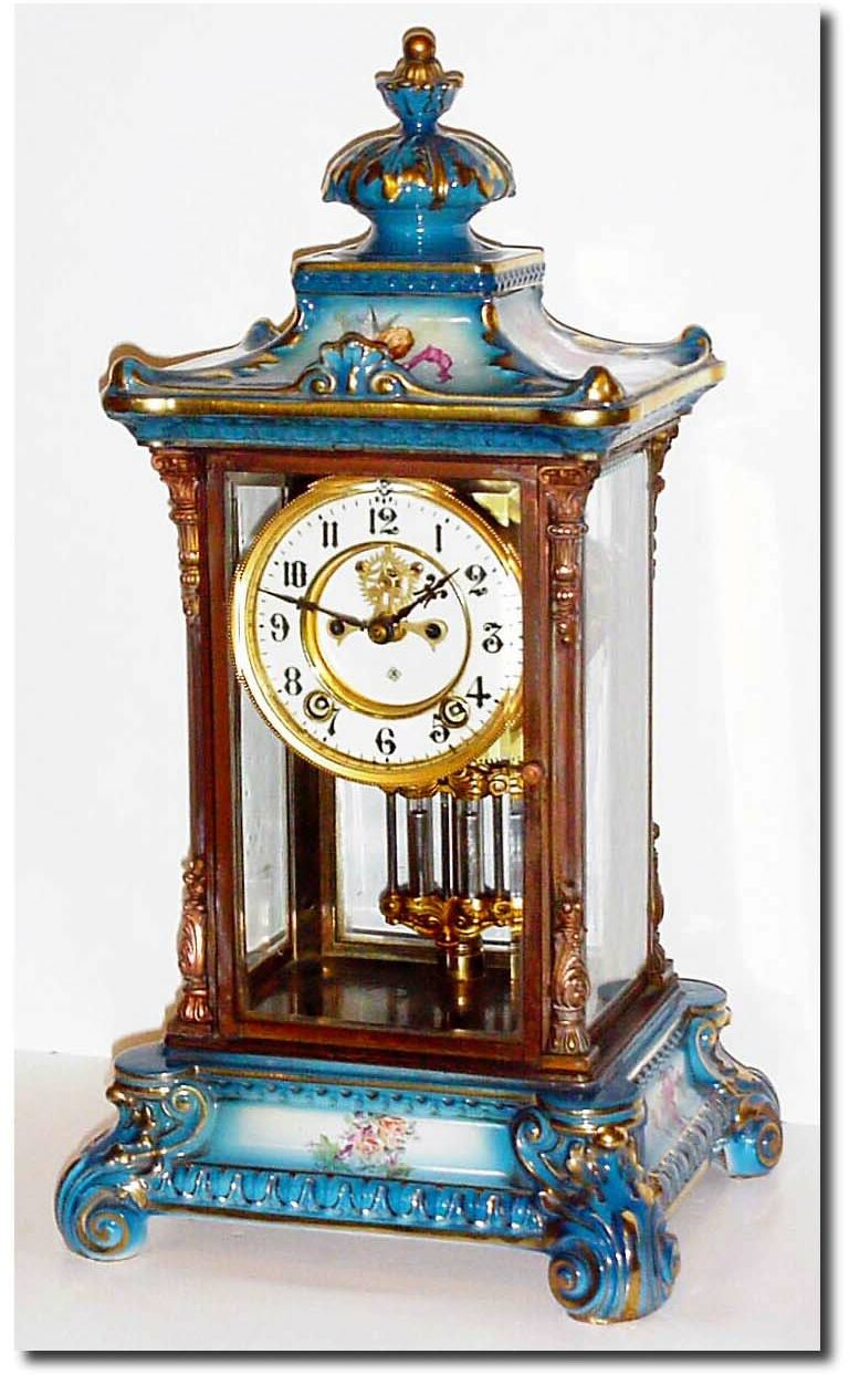 C.1914, Ansonia "Crystal Regulator No.2' in medium blue with yellow, pink and violet flowers, and with a winged cherub on the top. — Antique Clocks Price Guide