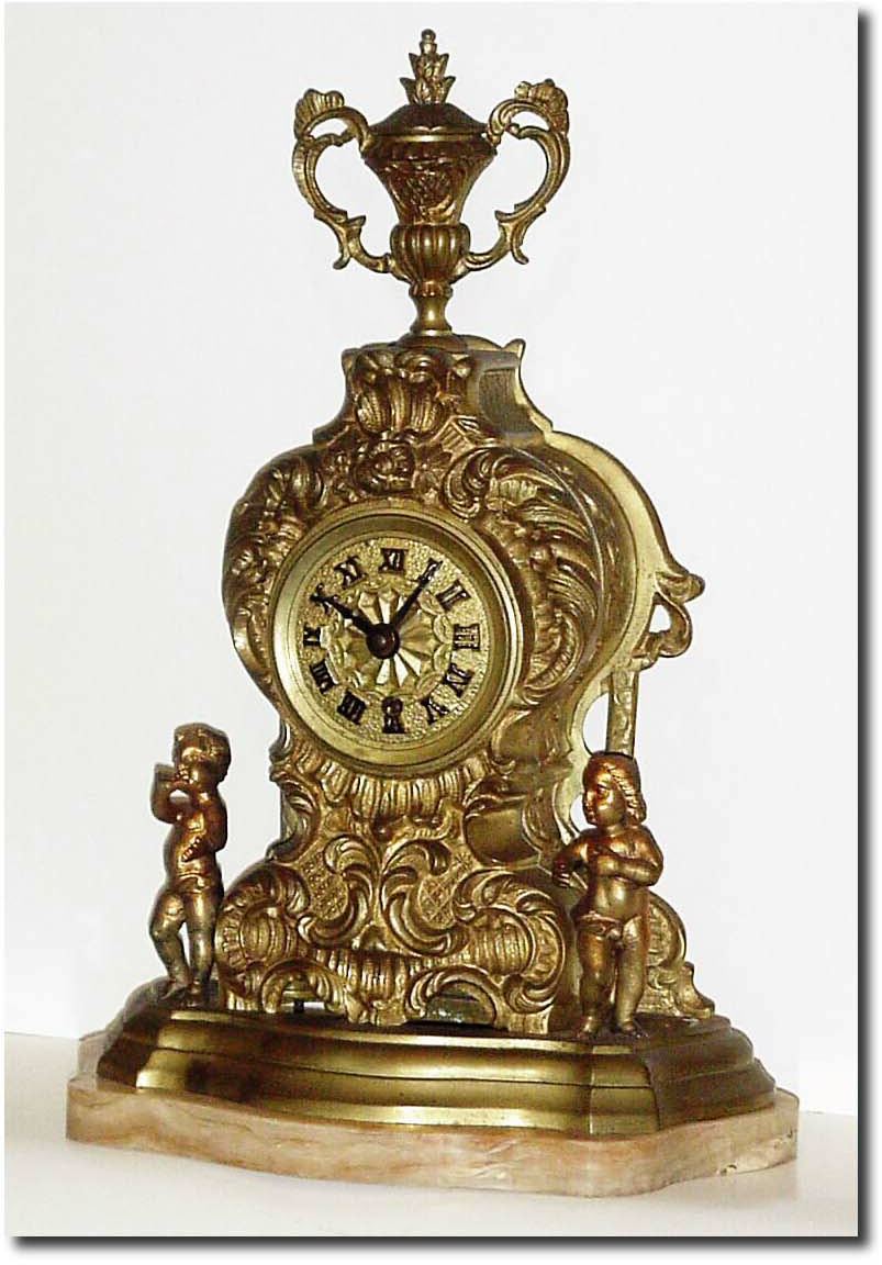 C.1910, French, ormolu on marble figural clock, two figures beside a floral tower, surmounted by an urn. — Antique Clocks Price Guide