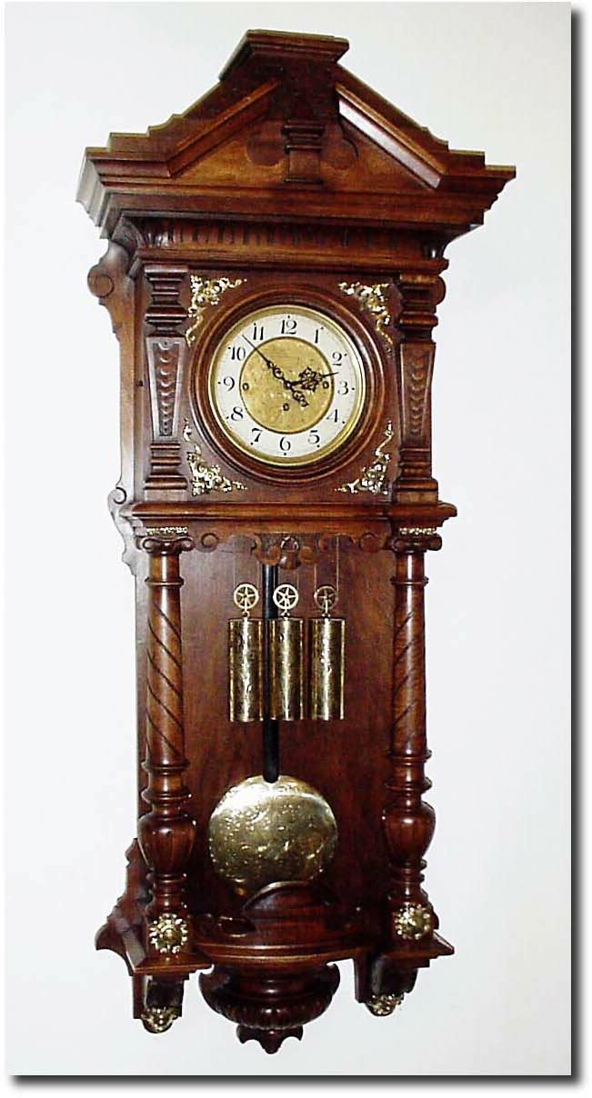 C.1885, Austrian, 3-Weight Grand Sonnerie wall clock in an interesting "open well' design, the walnut case with full turned columns and with 10 pieces of heavy cast brass trim. — Antique Clocks Price Guide
