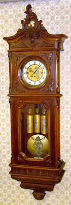 C.1900, Austrian, 3-Wt Grand Sonnerie, Second baroque walnut cased wall clock, with Art Nouveau decorations on the dial center, weights and pendulum. Full quarter strike on rods. — Antique Clocks Price Guide