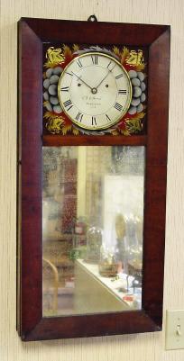 C.1825, B. Morrill, Boscawen, NH, mirror front wall clock with beveled frame, 8-day time and strike, the case back relieved to accept the movement and still present thin silhouette. — Antique Clocks Price Guide