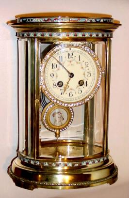 C.1900, French, Oval Crystal Regulator with cloisonne bands top and bottom and with brilliant surround on both pendulum and bezel. And a bonus of a portrait in the center of the pendulum. — Antique Clocks Price Guide