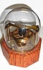 C.1996 (dated), D. J. Moore, Spring detent Escapement model, on a tiger maple base, with American open spring movement as power source held within the base, and with dome.