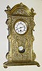 C.1890, German, Mini Shelf Clock, tall clock motif, a cast brass facade, base and crested top, the well made 8-day movement with 7 wheels in the train, going for a week.