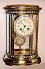 C.1900, French, Oval Crystal Regulator with cloisonne bands top and bottom and with brilliant surround on both pendulum and bezel. And a bonus of a portrait in the center of the pendulum.