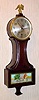 C.1920, Sessions Clock Co, Small Banjo timepiece, with 6" dial and stagecoach tablet in the bottom door, 8-day pendulum movement.