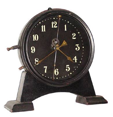 C.1921 English Gravity timepiece, The 30-hour movement is driven by a weight inside the case that raised by a lever on the side with visible escapement and a compound bar-bell pendulum. Serial No. L4447 — Antique Clocks Price Guide
