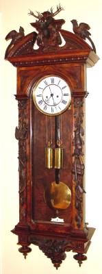 C.1970, German, Lenzkirch, Regulator No. 321, Hunting Motif wall clock, profusely carved with deer head, pheasant, rabbit, percussion rifle, powder horns, mini ball (bullet) holders, bow, arrows and quiver. — Antique Clocks Price Guide