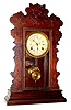 C.1900, Waterbury, Walnut GIBSON model calendar kitchen clock, 8-day time and strike.