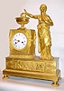 C.1810, French, Barancourt, Ormolu Figural clock, 8-day time and strike, the goddess Athena in a pensive pose. The frieze below the clock with court scene, a gowned lady pleading for mercy from a king with outstretched arm and lancet, a branding fire smoldering behind her, and three warriors with shields standing to the right.