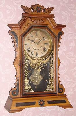 C.1885, E. Ingraham and Co., "FAULTLESS" , 8-Day time and strike gingerbread clock, in a two tone maple case with ebonized accents. — Antique Clocks Price Guide