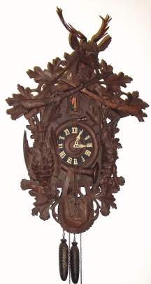 C.1930, German, A. Hummel, Villingen, (signed) Large 3-note Wall Trumpeter, in a carved case with hunter motif. — Antique Clocks Price Guide