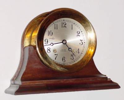 C.1978 Chelsea Clock Co., Boston. Mass., 8-day ship's bell clock, serial no. 813312 in a polished brass case, on original mahogany stand, 4 1/2" dial. — Antique Clocks Price Guide