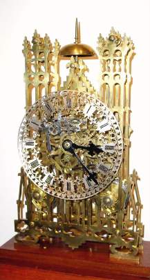 C.1890, English, 2-Chain-Fusee Skeleton Clock, striking the hours on a large coiled wire gong and the halves on a bell at top, and with fine 5-spoke wheels throughout, in a glazed case of mahogany and beveled glass. — Antique Clocks Price Guide